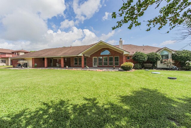 4222 Skylane Rd, Beach City, TX 77523 - rear view of property with a chimney, a lawn, and brick siding