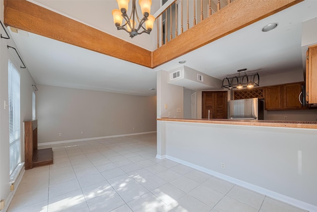 2011 Converse St, Houston, TX 77006 - kitchen featuring freestanding refrigerator, light tile patterned flooring, a chandelier, brown cabinets, and baseboards