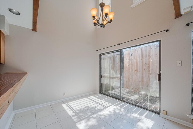 2011 Converse St, Houston, TX 77006 - unfurnished dining area featuring a chandelier, tile patterned floors, baseboards, and a high ceiling