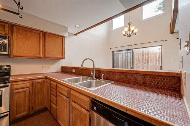 2011 Converse St, Houston, TX 77006 - kitchen featuring a sink, appliances with stainless steel finishes, brown cabinetry, a chandelier, and a towering ceiling