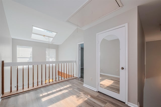 2011 Converse St, Houston, TX 77006 - hallway with attic access, wood finished floors, vaulted ceiling, and baseboards