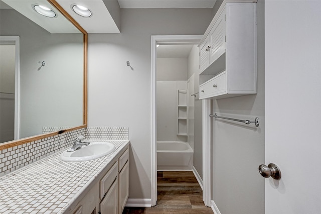 2011 Converse St, Houston, TX 77006 - full bathroom with wood finished floors, vanity, tasteful backsplash, shower / washtub combination, and baseboards