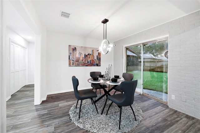 5702 Indigo St, Houston, TX 77096 - dining space with wood finished floors, brick wall, and a chandelier