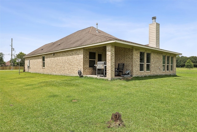 10025 Jason Ct, Beaumont, TX 77705 - back of property featuring a chimney, brick siding, a lawn, and a patio