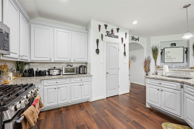 10025 Jason Ct, Beaumont, TX 77705 - kitchen with stainless steel appliances, tasteful backsplash, white cabinetry, dark wood-style flooring, and light stone counters