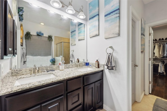 10025 Jason Ct, Beaumont, TX 77705 - full bath with a spacious closet, a shower stall, double vanity, and tile patterned floors
