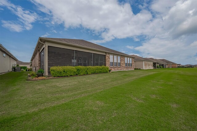 430 Seaside Sparrow Way, Richmond, TX 77469 - back of house featuring brick siding, a lawn, and a sunroom