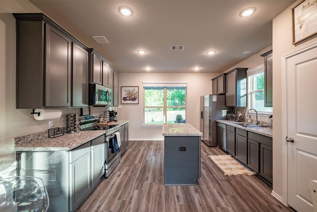 907 Crystal River Rd, Conroe, TX 77316 - kitchen with stainless steel appliances, a center island, wood finished floors, plenty of natural light, and recessed lighting