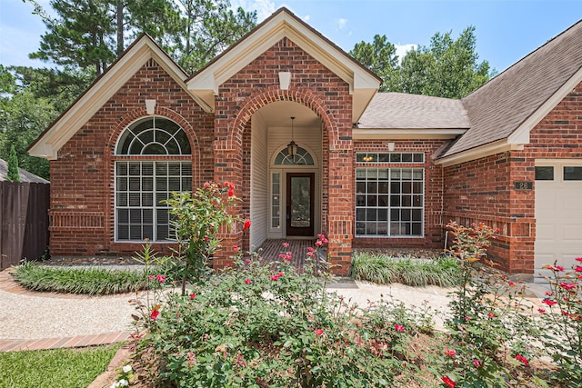 26 Skyland Pl, The Woodlands, TX 77381 - view of front facade featuring brick siding, a shingled roof, and an attached garage