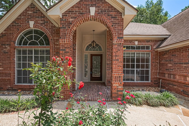 26 Skyland Pl, The Woodlands, TX 77381 - entrance to property featuring roof with shingles and brick siding