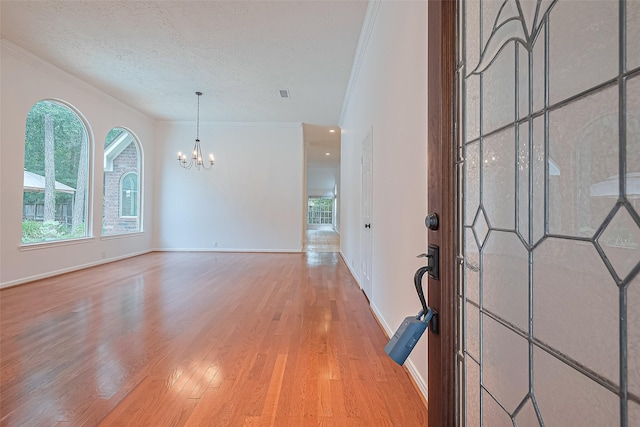 26 Skyland Pl, The Woodlands, TX 77381 - entrance foyer with a chandelier, wood finished floors, crown molding, and a textured ceiling