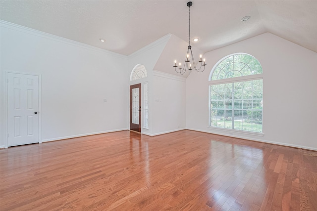 26 Skyland Pl, The Woodlands, TX 77381 - spare room with a chandelier, light wood-type flooring, vaulted ceiling, and crown molding