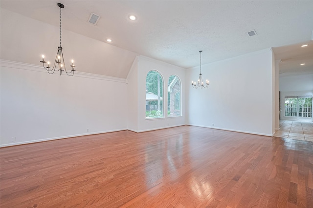 26 Skyland Pl, The Woodlands, TX 77381 - empty room featuring a chandelier, light wood-style floors, vaulted ceiling, recessed lighting, and ornamental molding
