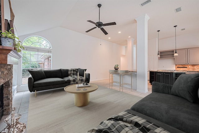 26 Skyland Pl, The Woodlands, TX 77381 - living room featuring light tile patterned floors, a ceiling fan, ornate columns, a fireplace, and high vaulted ceiling