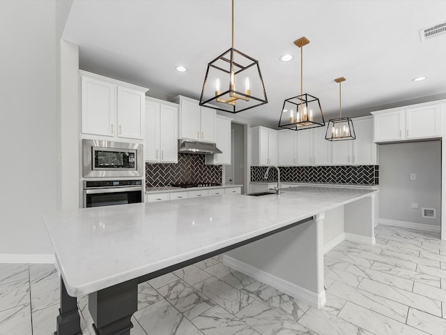 2107 Jitterbug Ln, Katy, TX 77493 - kitchen with stainless steel appliances, light marble finish floors, a sink, baseboards, and under cabinet range hood