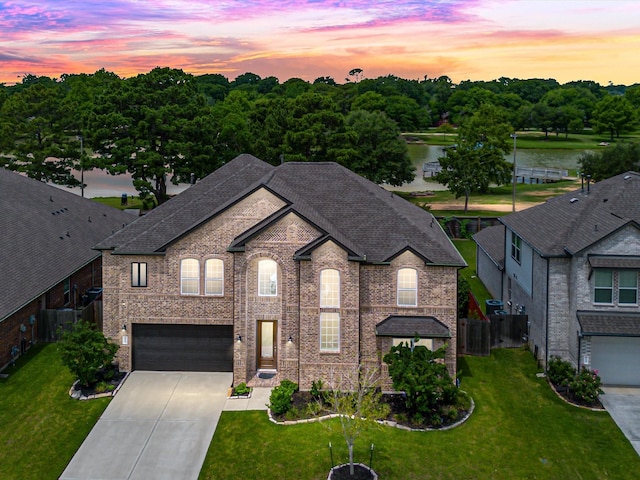 2107 Jitterbug Ln, Katy, TX 77493 - french country style house with driveway, a garage, a water view, roof with shingles, and brick siding
