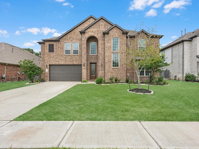 2107 Jitterbug Ln, Katy, TX 77493 - view of front facade featuring brick siding, driveway, a garage, and a front yard