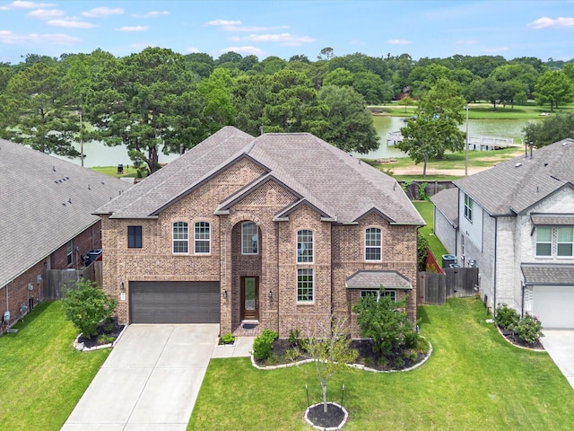 2107 Jitterbug Ln, Katy, TX 77493 - view of front of house featuring concrete driveway, an attached garage, brick siding, a water view, and a shingled roof