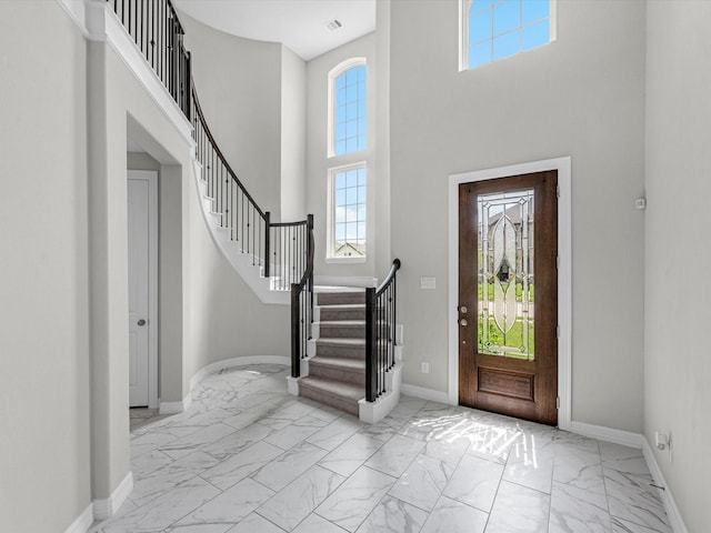 2107 Jitterbug Ln, Katy, TX 77493 - foyer entrance featuring light marble finish flooring, a high ceiling, baseboards, and stairway
