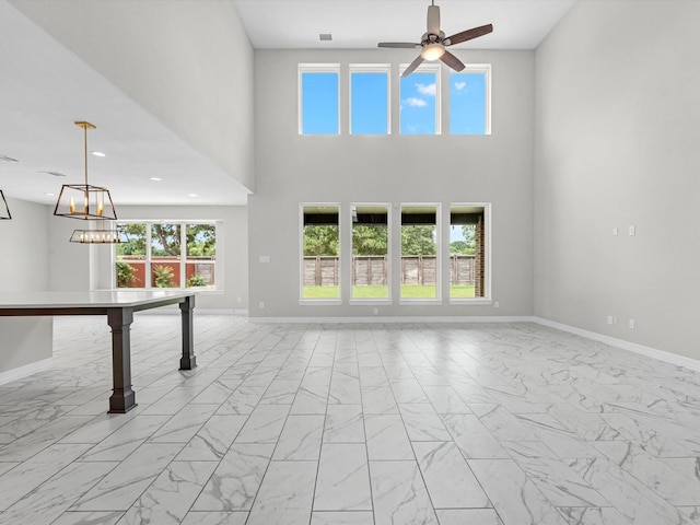 2107 Jitterbug Ln, Katy, TX 77493 - unfurnished living room with light marble finish floors, a ceiling fan, baseboards, and a high ceiling