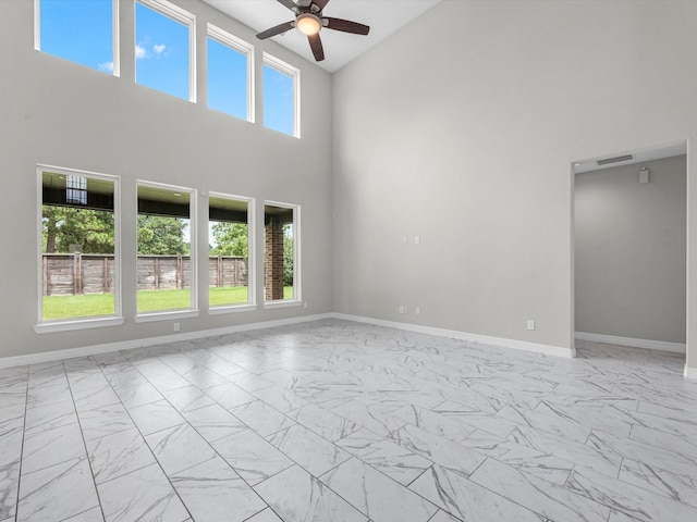 2107 Jitterbug Ln, Katy, TX 77493 - spare room featuring high vaulted ceiling, light marble finish flooring, ceiling fan, and baseboards
