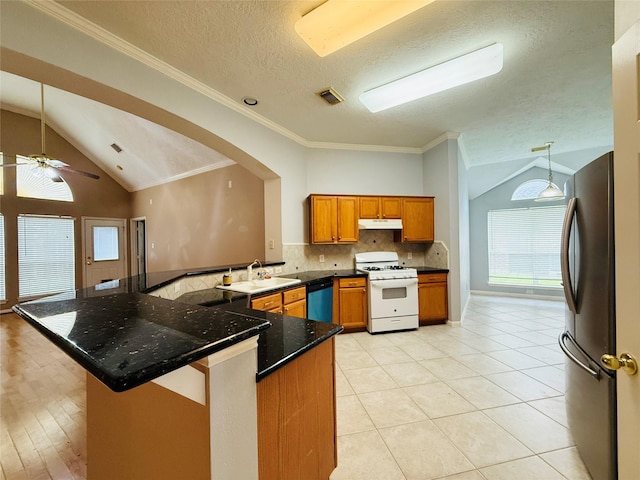 210 Cedar Lake Dr, League City, TX 77573 - kitchen featuring gas range gas stove, freestanding refrigerator, lofted ceiling, under cabinet range hood, and brown cabinetry