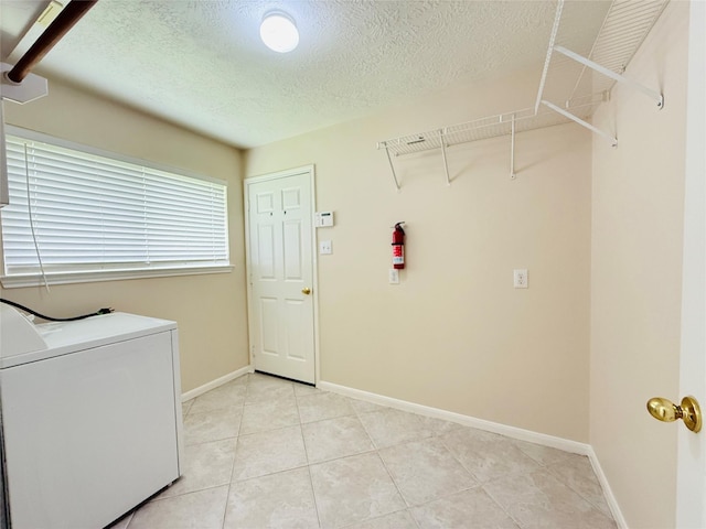 210 Cedar Lake Dr, League City, TX 77573 - washroom featuring washer / clothes dryer, a textured ceiling, and light tile patterned floors