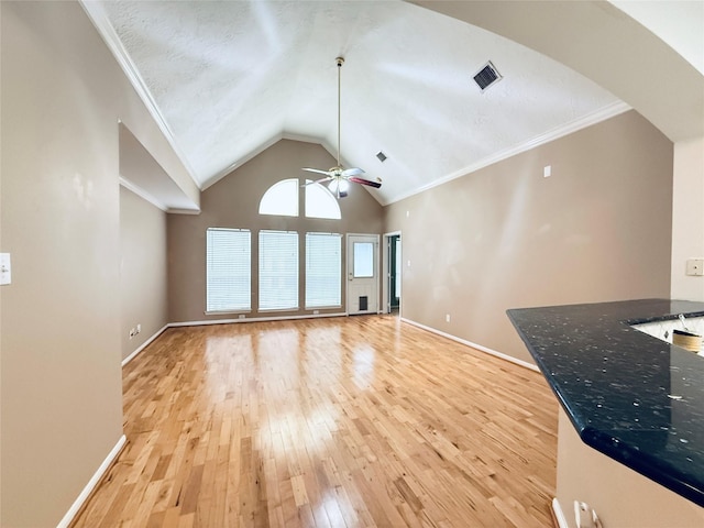 210 Cedar Lake Dr, League City, TX 77573 - unfurnished living room with ceiling fan, light wood-style flooring, arched walkways, lofted ceiling, and ornamental molding