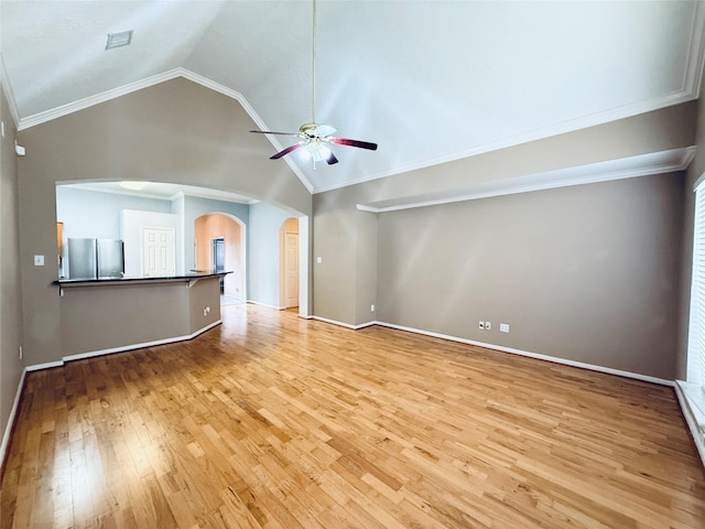 210 Cedar Lake Dr, League City, TX 77573 - unfurnished living room with arched walkways, ceiling fan, light wood-style flooring, vaulted ceiling, and crown molding