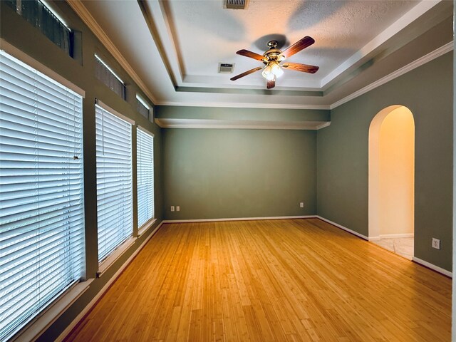 210 Cedar Lake Dr, League City, TX 77573 - unfurnished room with a raised ceiling, arched walkways, a ceiling fan, wood finished floors, and crown molding