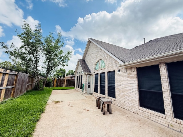 210 Cedar Lake Dr, League City, TX 77573 - rear view of house with a shingled roof, brick siding, a patio, and a fenced backyard
