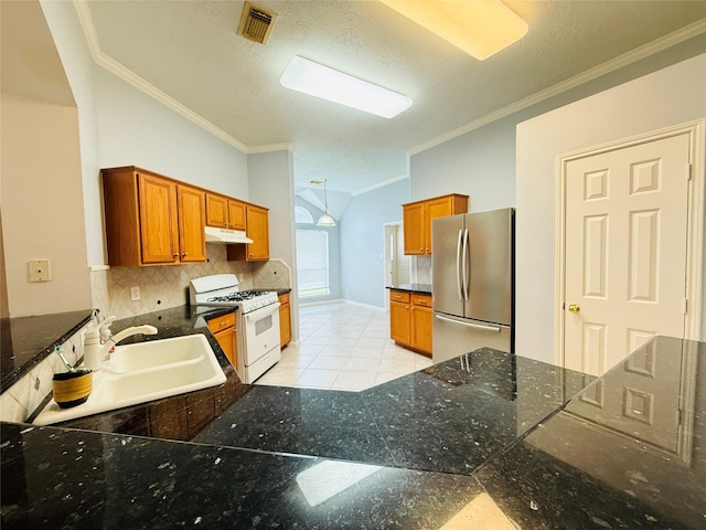 210 Cedar Lake Dr, League City, TX 77573 - kitchen featuring freestanding refrigerator, white range with gas cooktop, under cabinet range hood, crown molding, and decorative backsplash