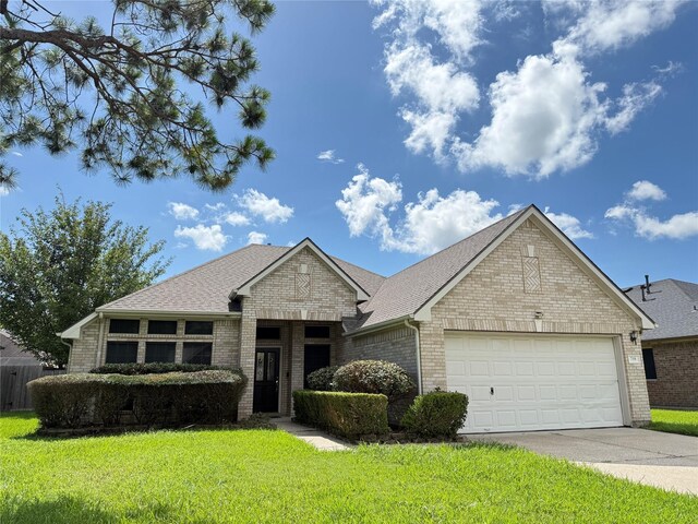 210 Cedar Lake Dr, League City, TX 77573 - view of front of house with brick siding, a garage, a front lawn, concrete driveway, and roof with shingles