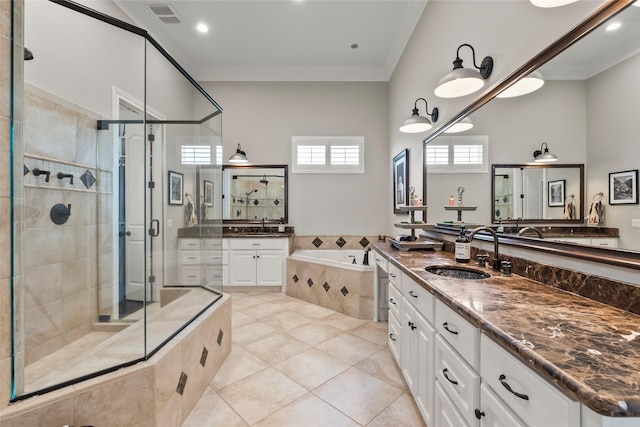 2112 Washington Ave, Alvin, TX 77511 - bathroom with a stall shower, a bath, two vanities, crown molding, and tile patterned flooring