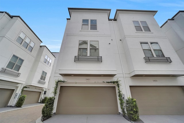 5401 Larkin St, Houston, TX 77007 - view of property with stucco siding, an attached garage, and driveway