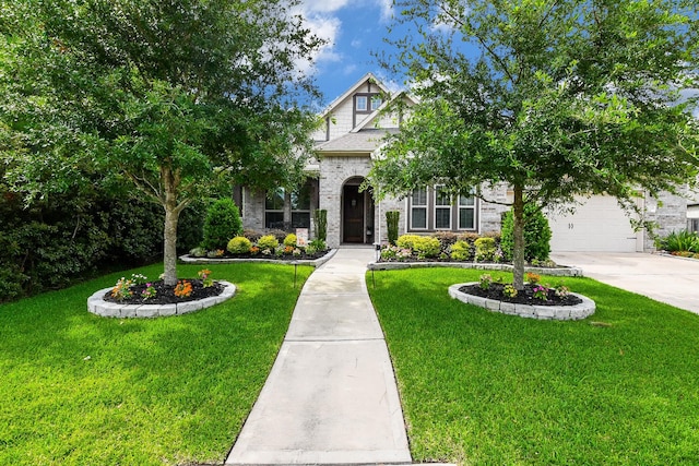 13326 Hartford Bay Trl, Cypress, TX 77429 - tudor-style house with concrete driveway, a front yard, a garage, and brick siding