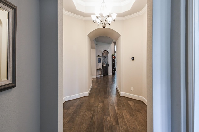 13326 Hartford Bay Trl, Cypress, TX 77429 - hall featuring arched walkways, a chandelier, a tray ceiling, dark wood-style floors, and ornamental molding