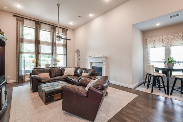 13326 Hartford Bay Trl, Cypress, TX 77429 - living room featuring wood finished floors, a glass covered fireplace, recessed lighting, ceiling fan, and a high ceiling