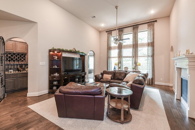 13326 Hartford Bay Trl, Cypress, TX 77429 - living area with high vaulted ceiling, dark wood-style floors, arched walkways, a glass covered fireplace, and recessed lighting