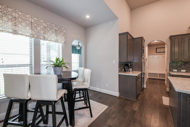 13326 Hartford Bay Trl, Cypress, TX 77429 - dining area featuring arched walkways, dark wood-style flooring, and recessed lighting