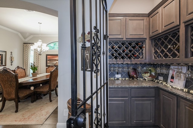 13326 Hartford Bay Trl, Cypress, TX 77429 - wine area with crown molding, a bar, a chandelier, and wood finished floors