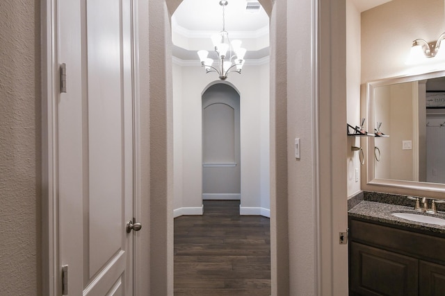 13326 Hartford Bay Trl, Cypress, TX 77429 - corridor featuring crown molding, a chandelier, dark wood finished floors, arched walkways, and a raised ceiling