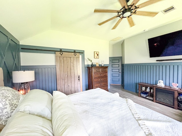 2900 Green Ash Ct, Conroe, TX 77301 - bedroom featuring a wainscoted wall, wood finished floors, lofted ceiling, and a ceiling fan
