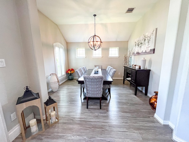 2900 Green Ash Ct, Conroe, TX 77301 - dining space featuring a chandelier, wood finished floors, baseboards, and vaulted ceiling