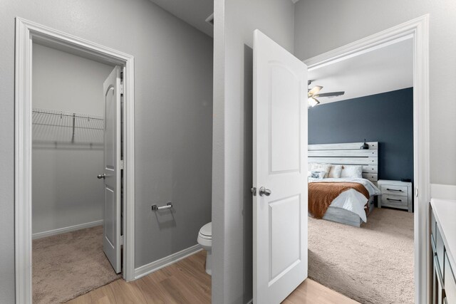 20730 Solstice Point Dr, Hockley, TX 77447 - bathroom featuring wood finished floors, toilet, ceiling fan, a spacious closet, and connected bathroom