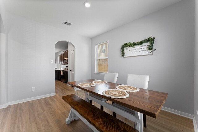 20730 Solstice Point Dr, Hockley, TX 77447 - dining space featuring arched walkways, light wood finished floors, and baseboards
