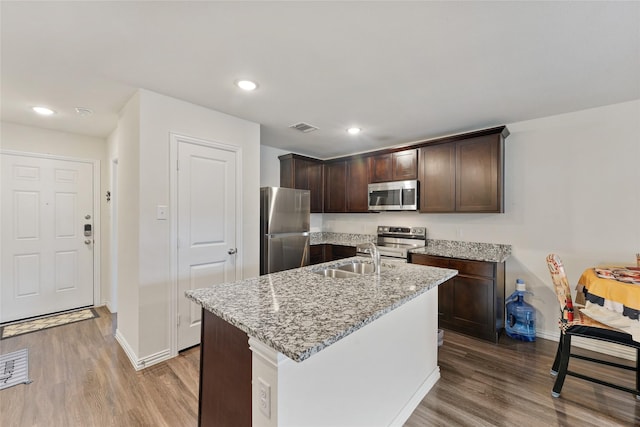 302 Connecticut St, Houston, TX 77029 - kitchen featuring appliances with stainless steel finishes, a sink, wood finished floors, baseboards, and recessed lighting