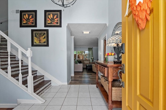 8307 Parasol Ln, Houston, TX 77064 - foyer entrance featuring stairway, light tile patterned floors, a textured ceiling, and baseboards