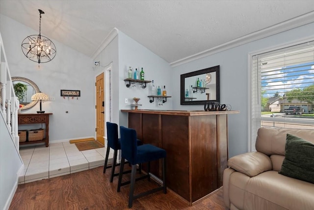 8307 Parasol Ln, Houston, TX 77064 - indoor dry bar with vaulted ceiling, a chandelier, wood finished floors, crown molding, and a textured ceiling