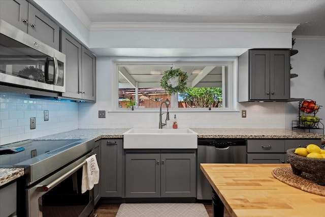 8307 Parasol Ln, Houston, TX 77064 - kitchen with appliances with stainless steel finishes, a sink, gray cabinets, ornamental molding, and open shelves